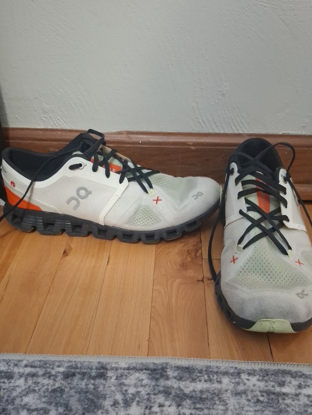 On Running Men’s Athletic Sneakers in White and Black with Orange Accents